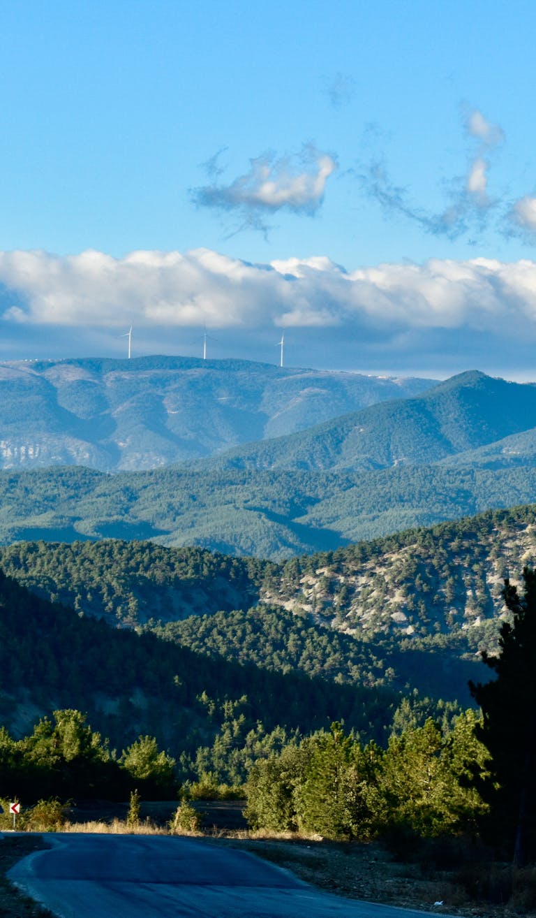Breathtaking view of mountains and wind turbines under a clear blue sky.