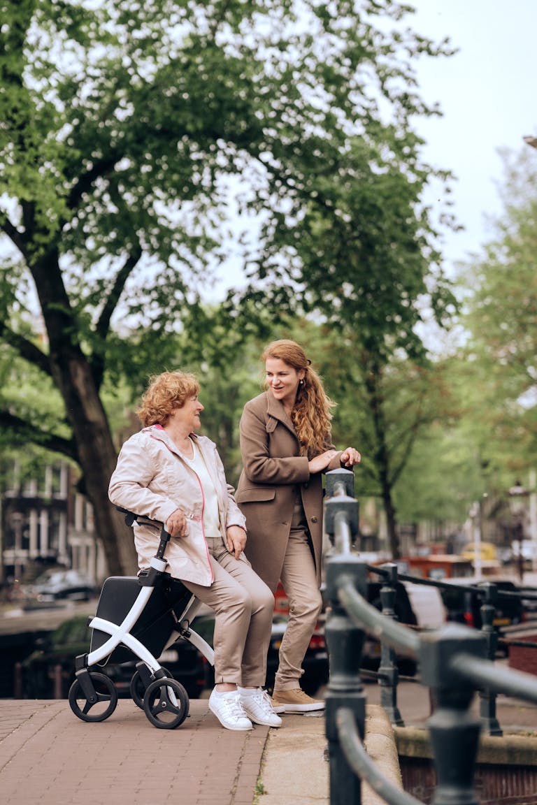 Mother and daughter enjoy a moment by Amsterdam's scenic canal with a mobility aid.