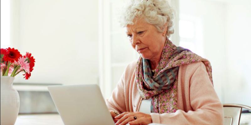 senior looking at laptop landscape (1)