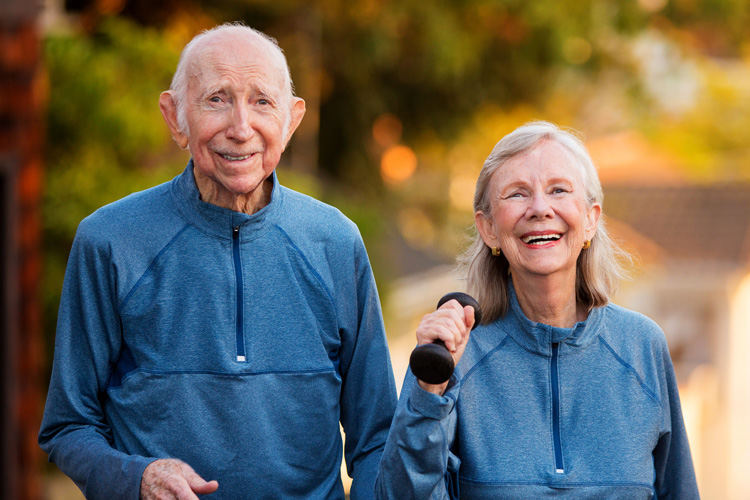 mullen residences senior couple walking outside with weights