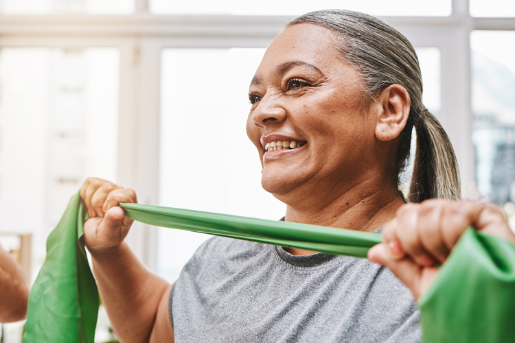 mullen residences senior woman exercising with resistance band